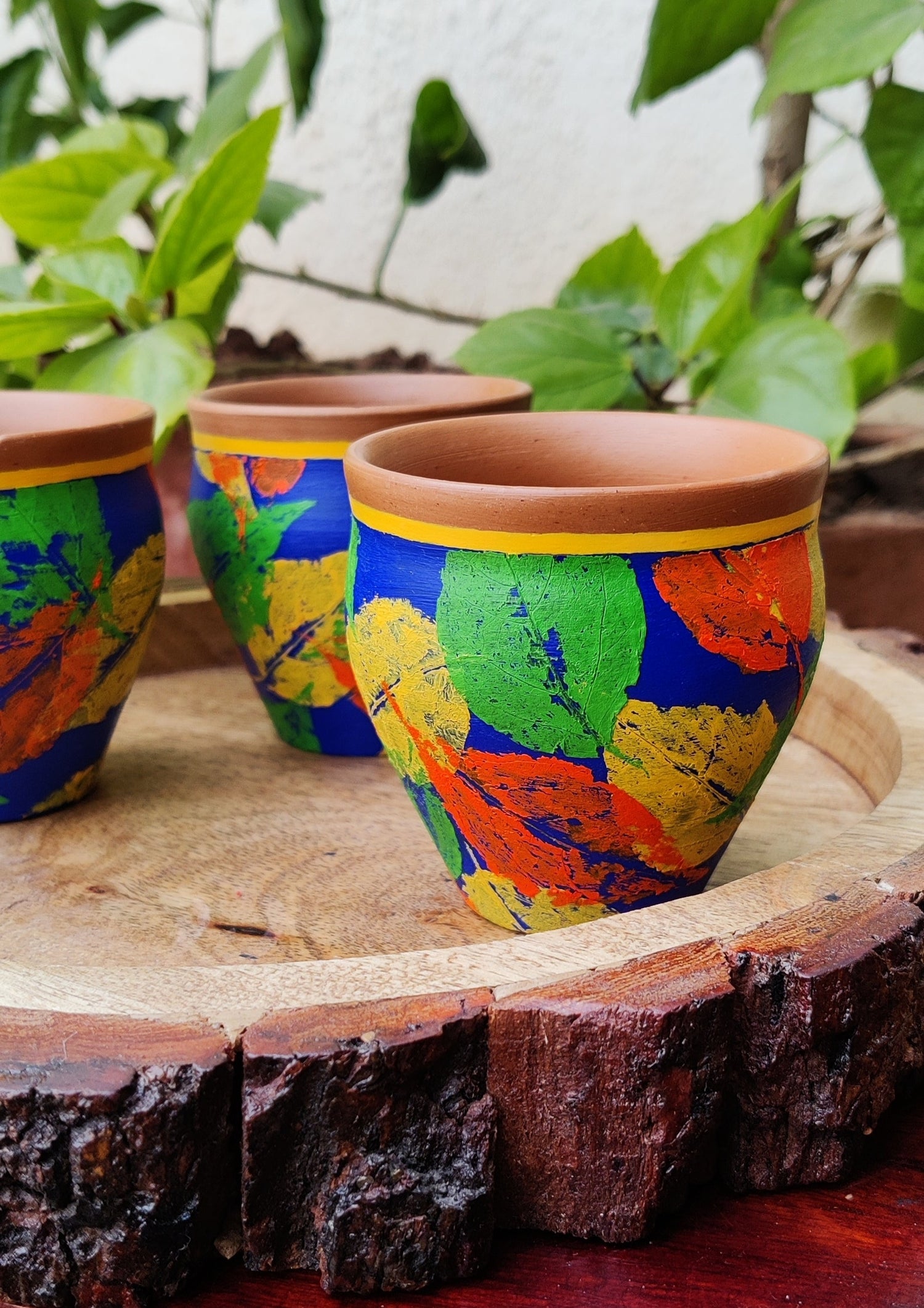 Blue color mini tea mugs with orange, yellow and green leaves print on it.